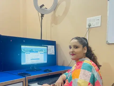 Student smiling at her computer workstation at Webultro Training